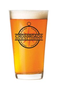 photo of full beer glass, with Crossroads Brewing Company logo