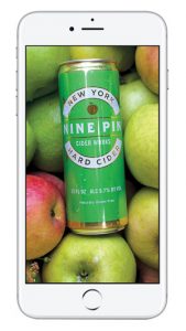 photo of white iPhone, with image of can of Nine Pin Hard Cider, and apples