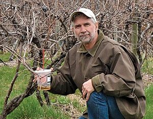 photo of Peter Jentsch, of the Hudson Valley Research Lab, kneeling in the lab's experimental vineyard
