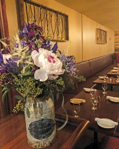 close-up of pitcher with flowers and tables inside 1839 Restaurant and bar 