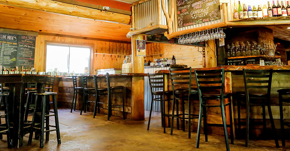 interior of tasting room with wood walls and black chairs