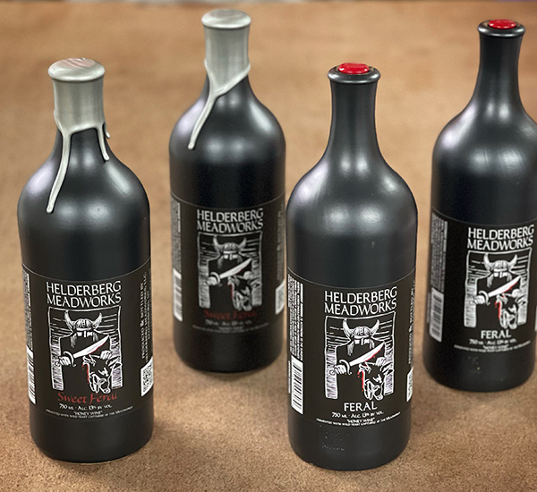 four black bottles of mead on a table
