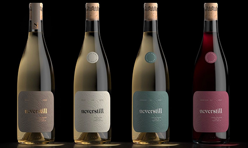 four wine bottles in a row on black background