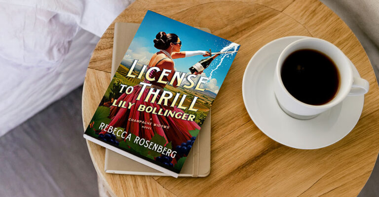 view of nightstand with coffee cup and book "License to Thrill, Lily Bollinger" by Rebecca Rosenberg.