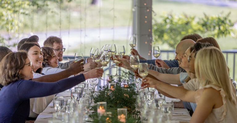 people at long table toasting with wine glasses